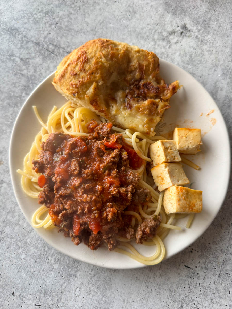 dinner plate with pasta, tofu and bread