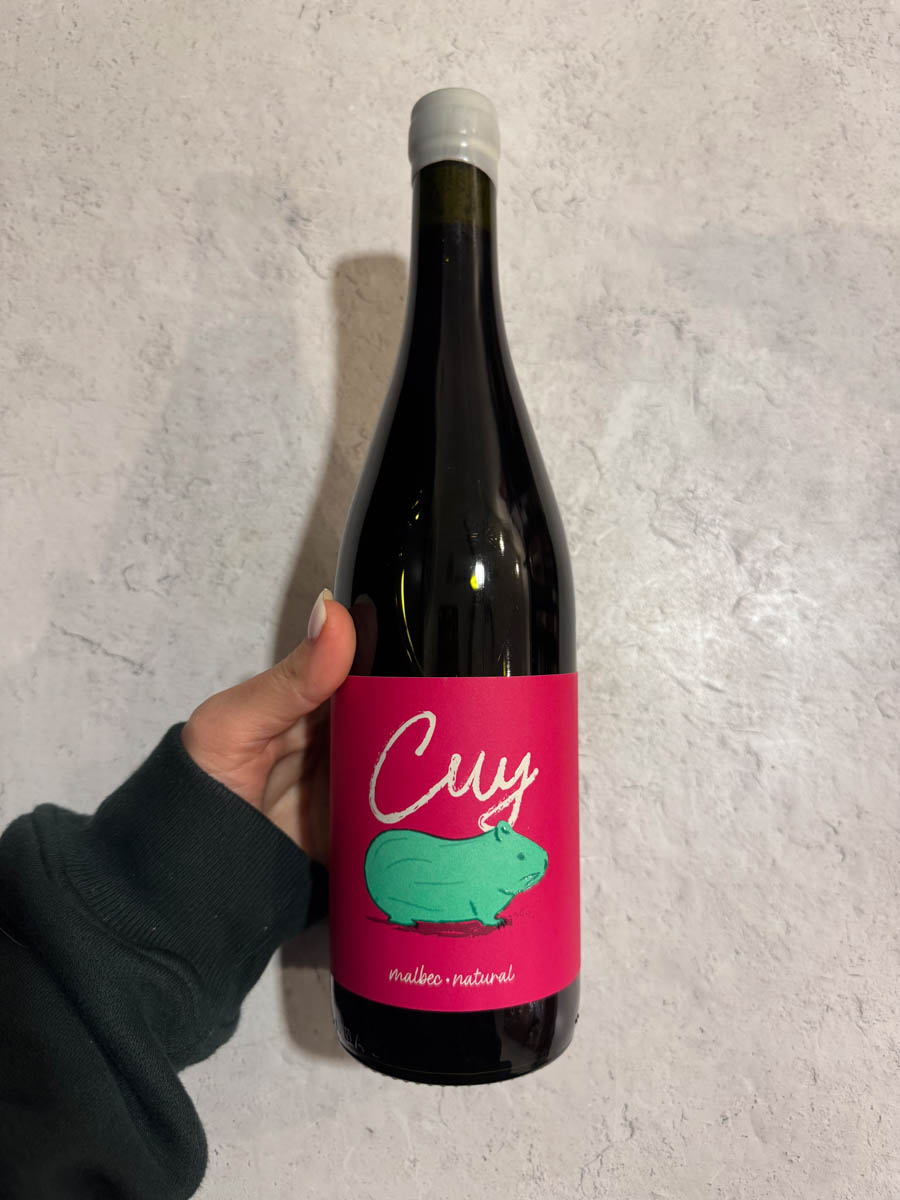 a bottle of Cuy wine in hand