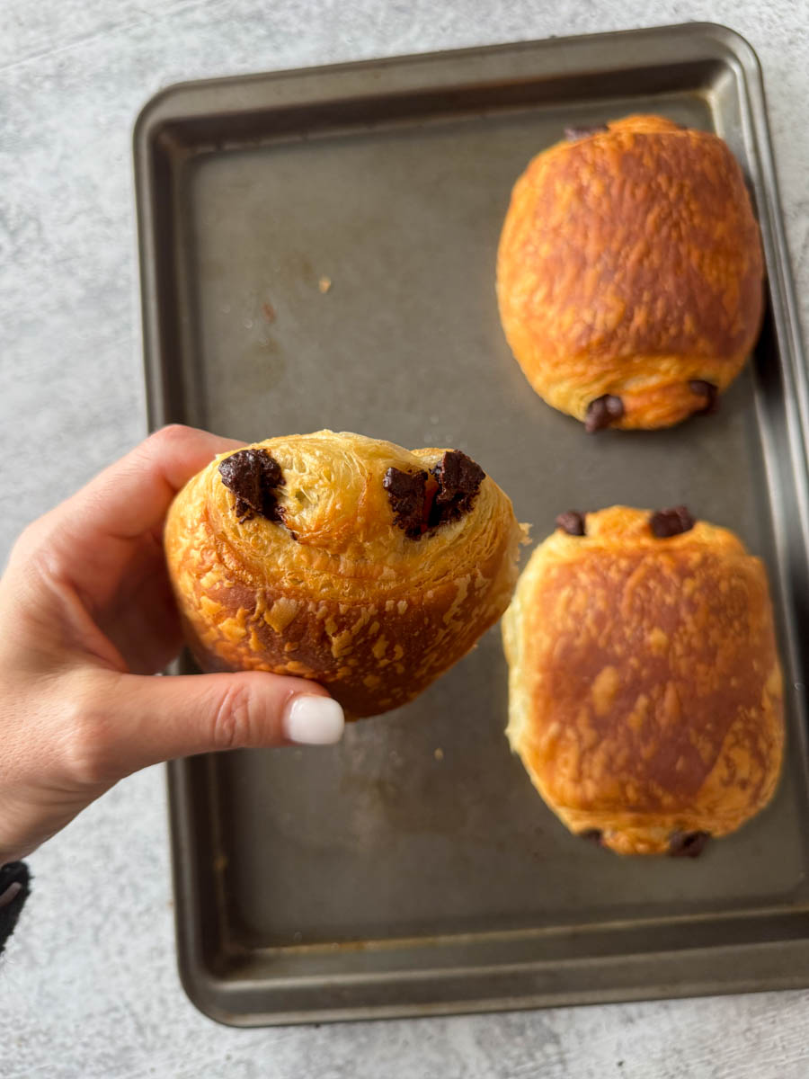 chocolate croissant in hand