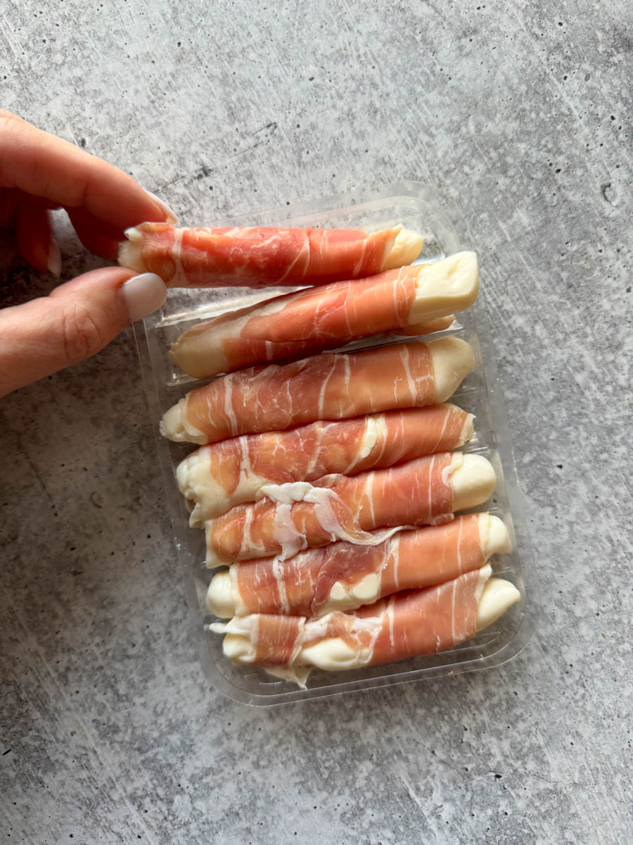 holding prosciutto wrapped fresh mozzarella