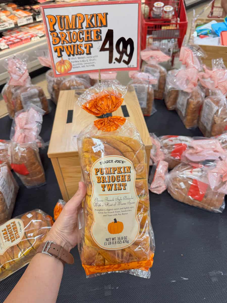 holding pumpkin brioche twist bread in hand in trader joe's