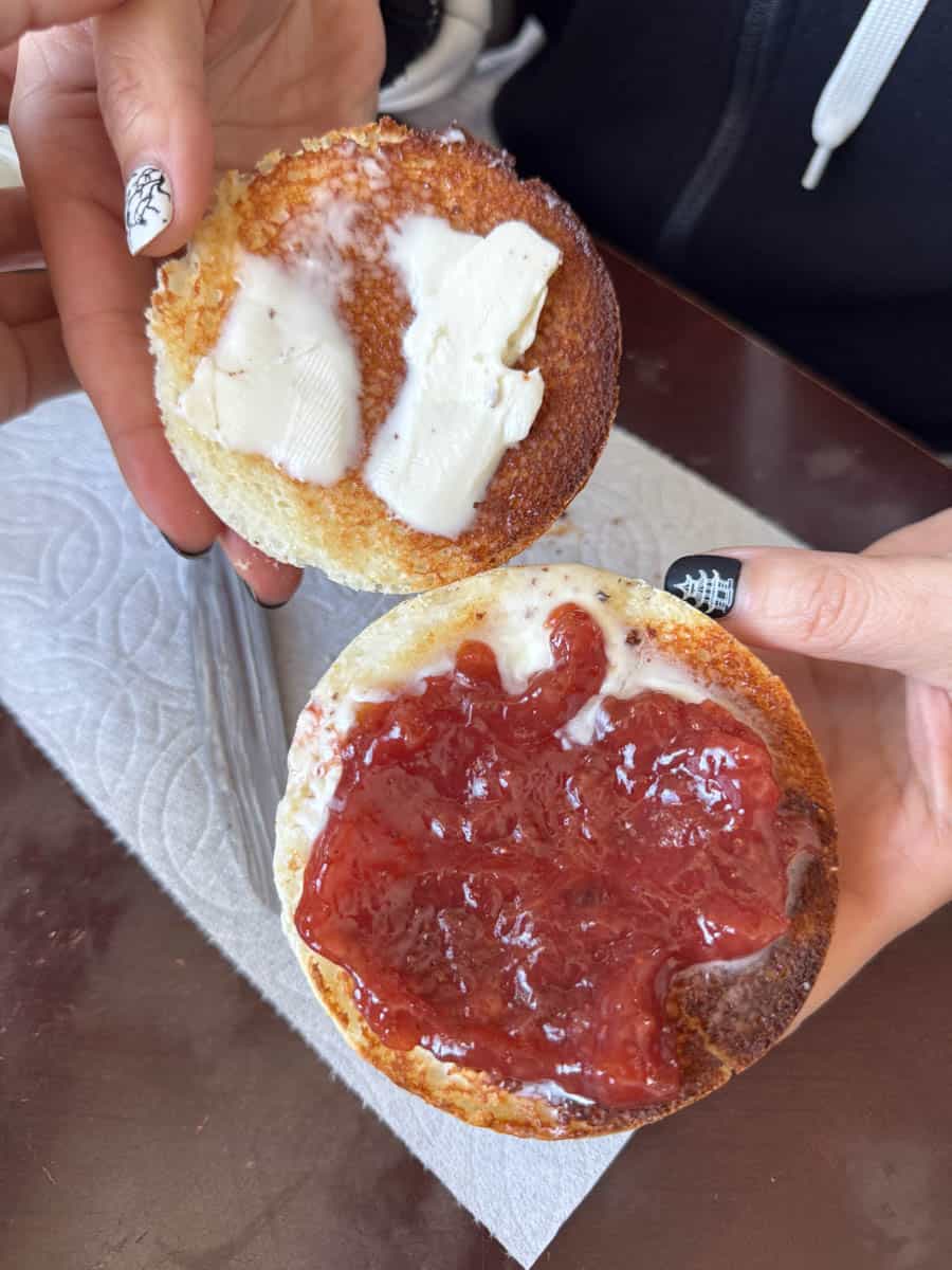 bread topped with butter and jam inhand
