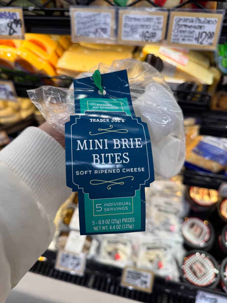 holding mini brie bites from trader joe's in hand in store