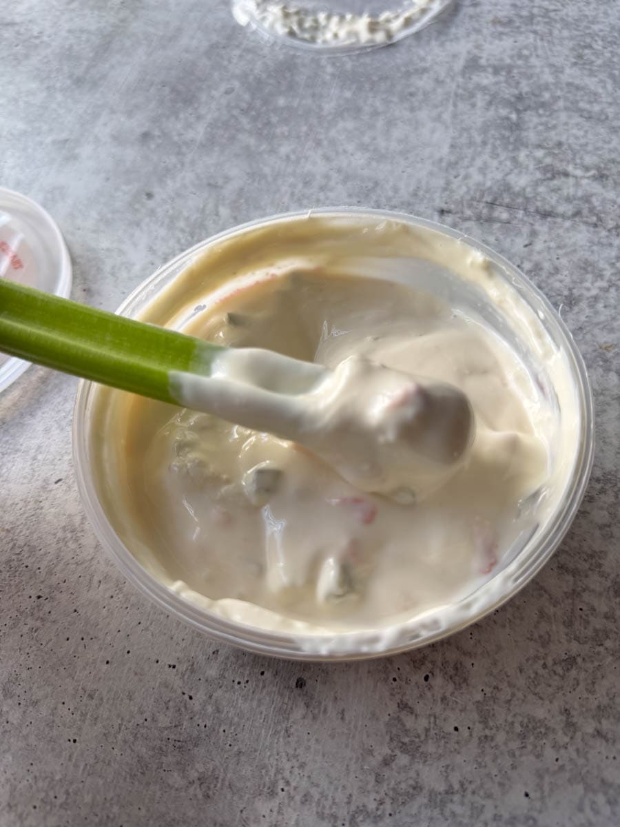 dipping celery in to the white queso dip