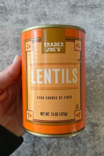 holding a can of trader joe's lentils in hand