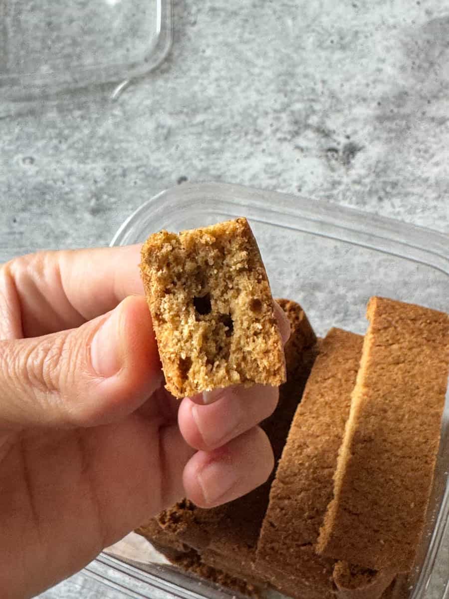 a piece of pumpkin biscotti in hand