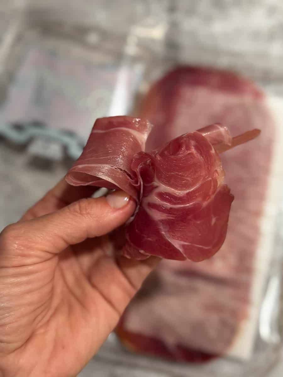 sliced prosciutto in hand