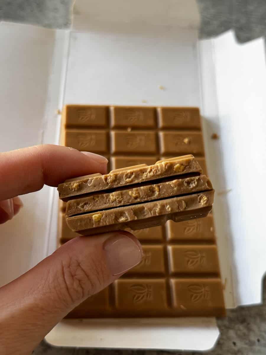 a piece of blonde bar from trader joe's in hand