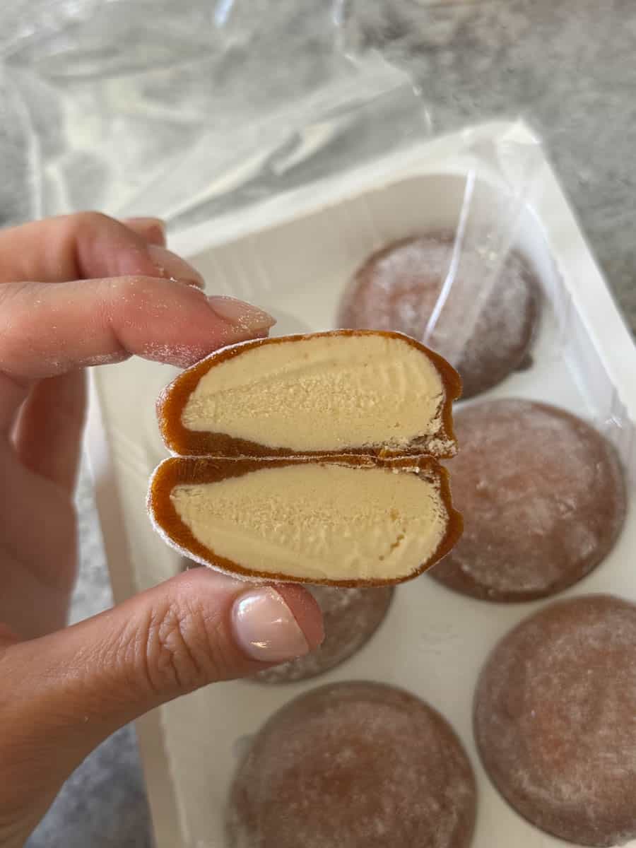 caramel mochi cut in half in hand
