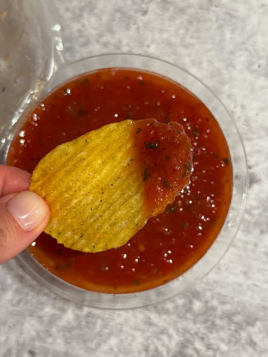 Chips dipped in spicy tomato salsa, perfect for snacking or sharing. Fresh, flavorful, and ideal for.