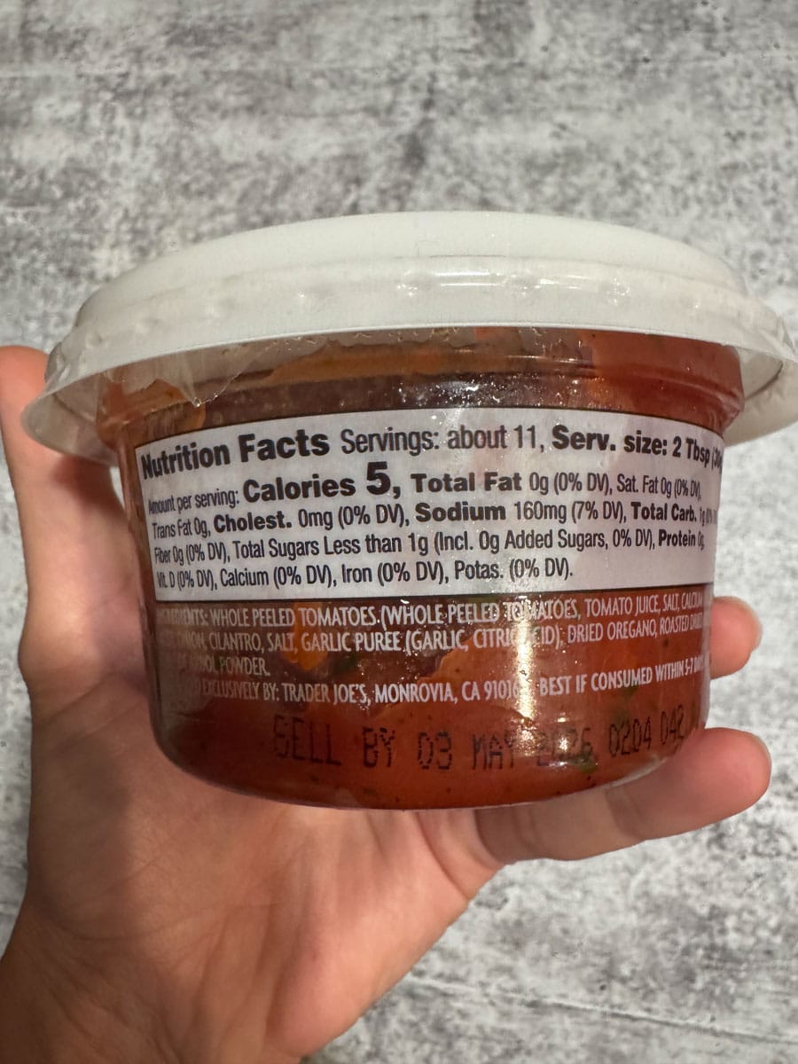 Fresh tomato salsa in a clear container with a white lid, ready to serve.