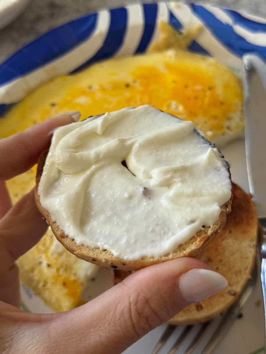 Bagel with cream cheese and fried eggs, perfect breakfast meal.