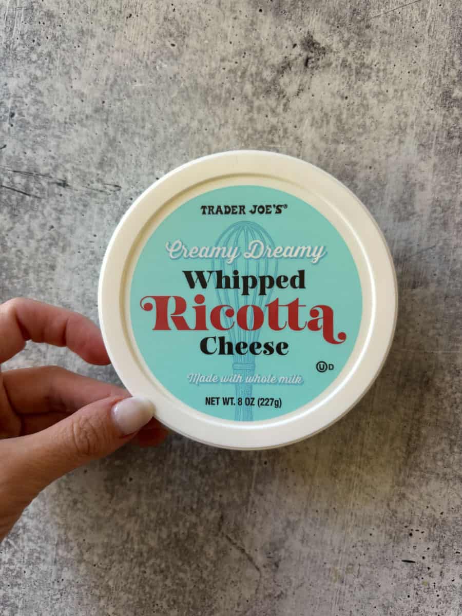 Trader Joe's creamy whipped ricotta cheese in a round container, ideal for spreads and cooking.