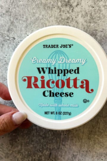 Trader Joe's creamy whipped ricotta cheese in a container, made with whole milk.